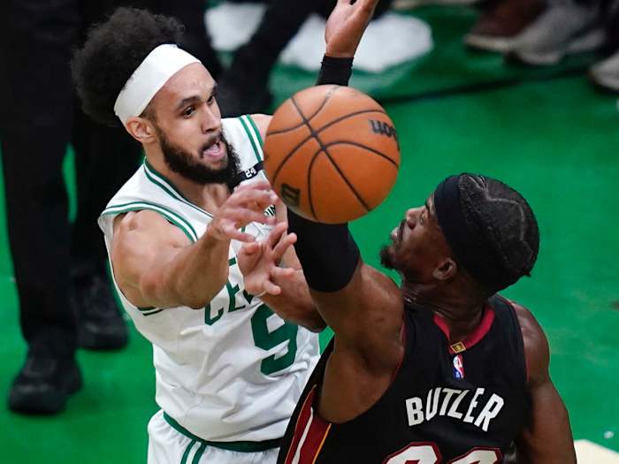 Boston Celtics guard Derrick White (9) passes the ball while pressured by Miami Heat forward Jimmy Butler (22) during the first half of Game 4 of the NBA basketball playoffs Eastern Conference finals, Monday, May 23, 2022, in Boston.